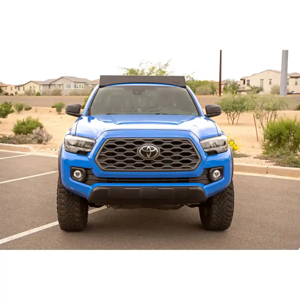 Blue Tacoma with Rago roof rack and round lights, front view