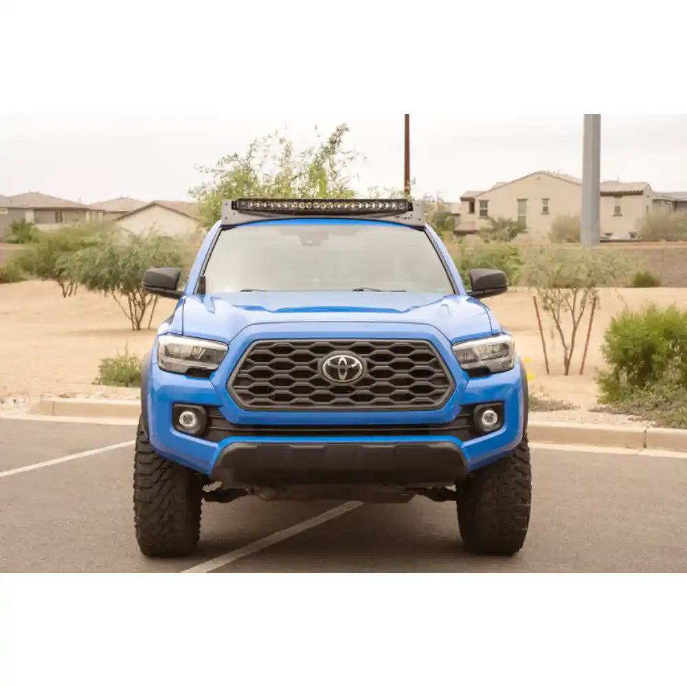 Blue 3rd Gen Tacoma with light bar in Rago roof rack, front view