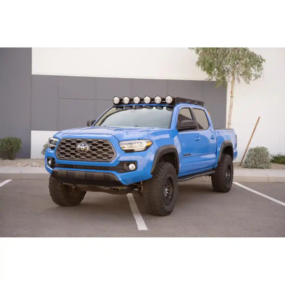 Blue 2016-2023 Tacoma with Rago roof rack and round lights, front three-quarter