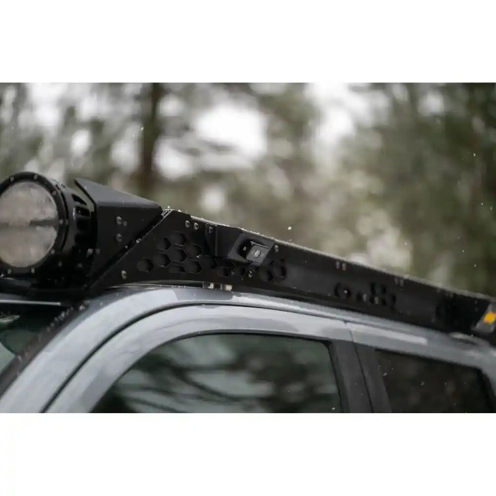 Round lights on Rago Tacoma roof rack in forest, close-up