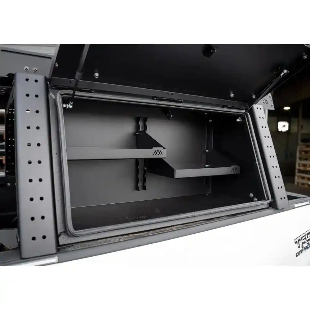 Open storage compartment with metal frame and black interior, showing 'backwoods' branding.