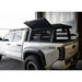 White Toyota Tacoma truck with an open bed cover in a garage.