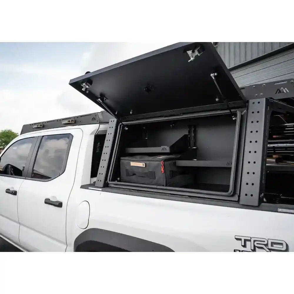 Truck bed with open storage compartment and 'TRD' branding on a white truck.