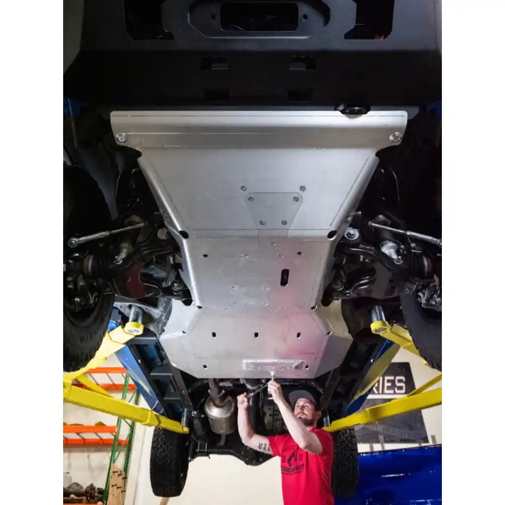 Mechanic installing Artec Industries Bellypan Skid Plates on a 4Runner