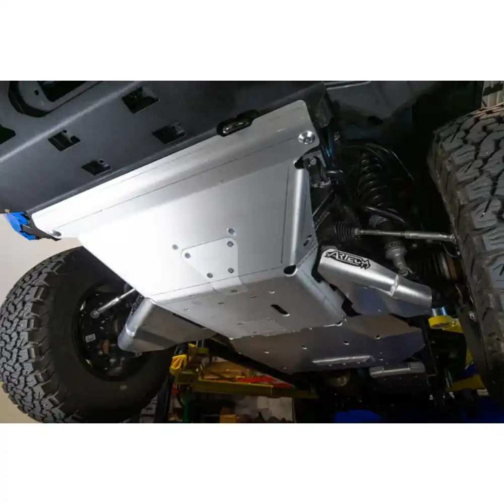 Close-up of a vehicle's undercarriage with a skid plate and 'Artec' branding.